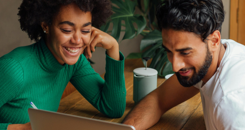 Two investors reviewing resources on a laptop